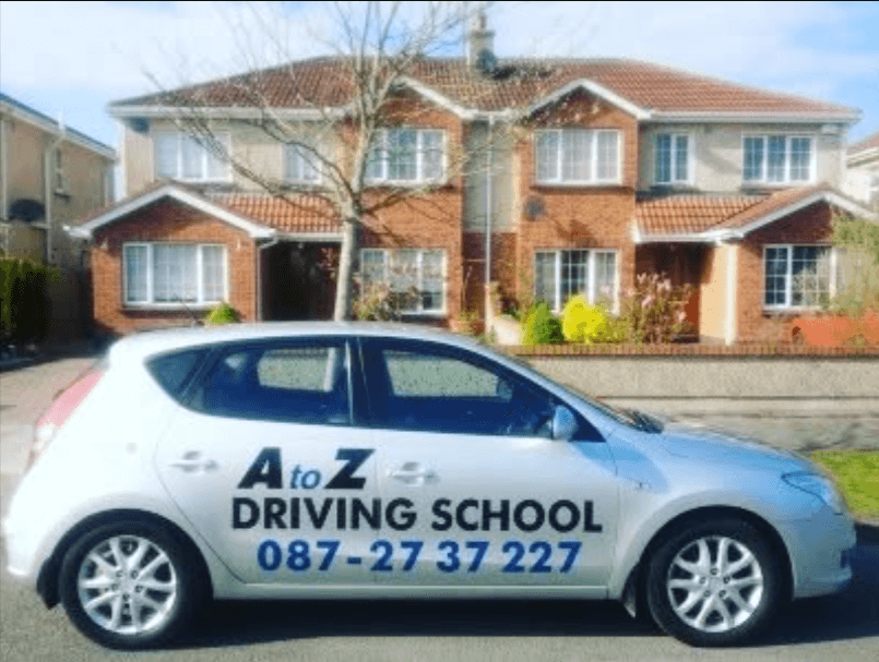 A to Z Driving School car parked in front of a house for driving lessons.